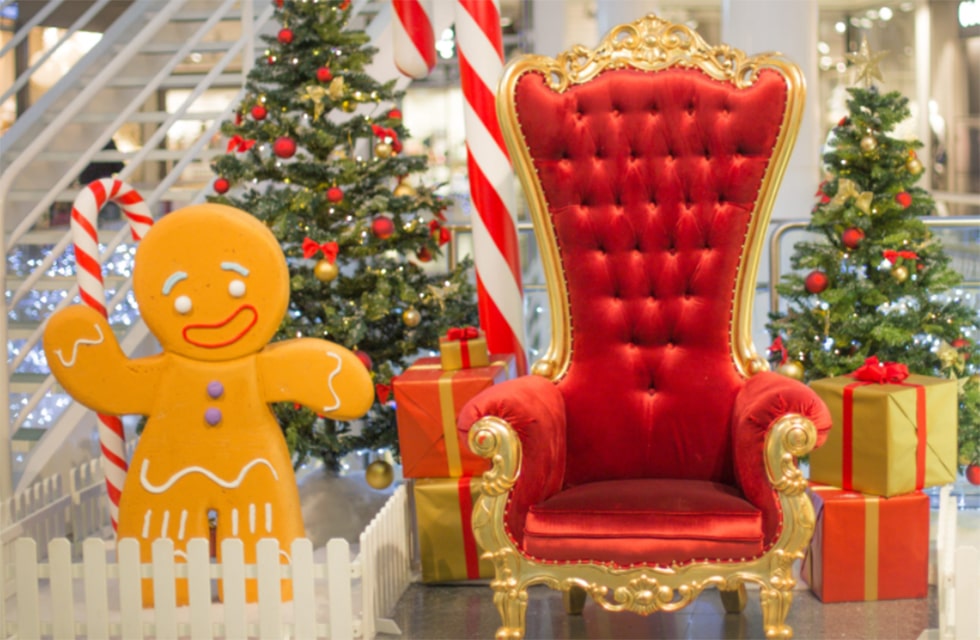 Décoration de Noel traditionnelle avec le fauteuil du père Noël, sapins, boites de cadeaux et personnages en gâteau