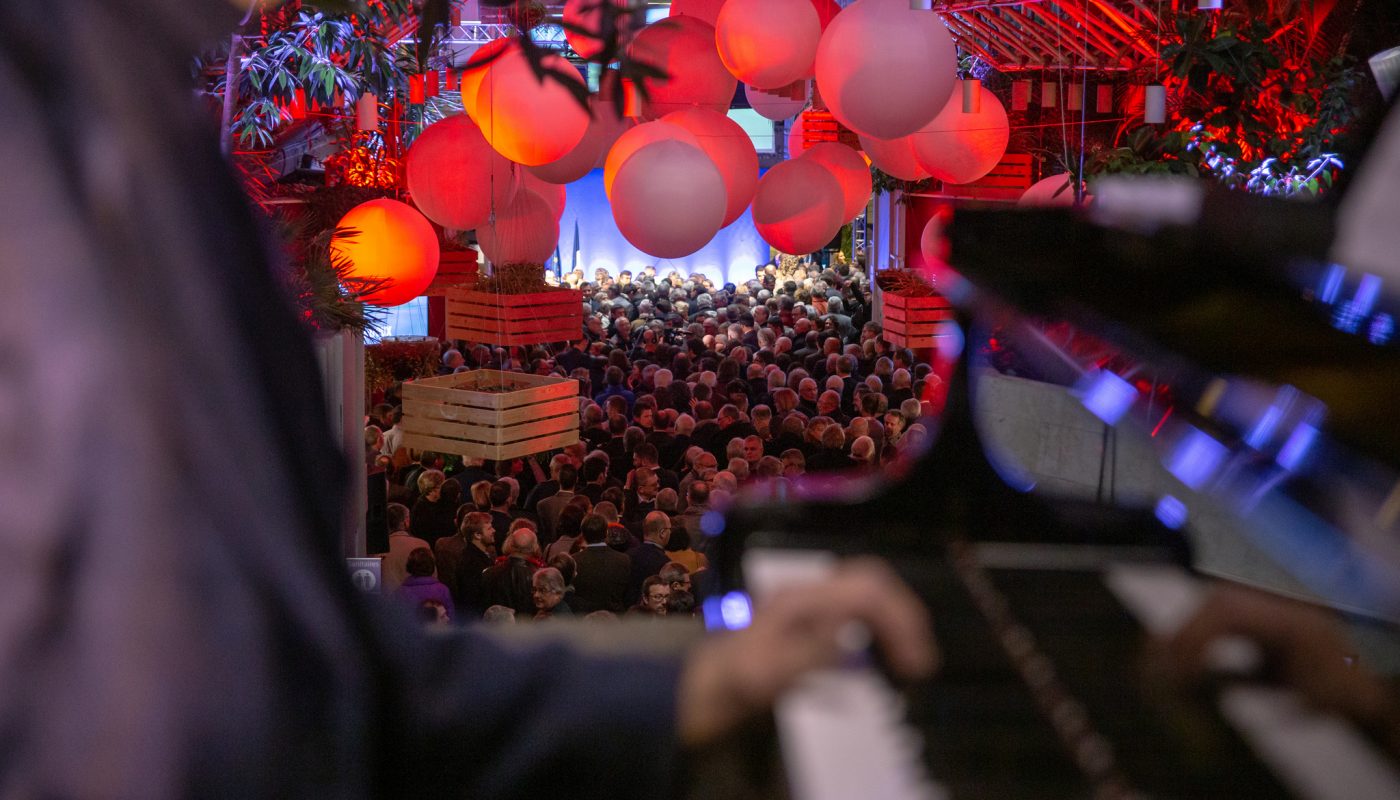 plafond de ballons suspendus avec un pianiste en premier plan et la foule en second