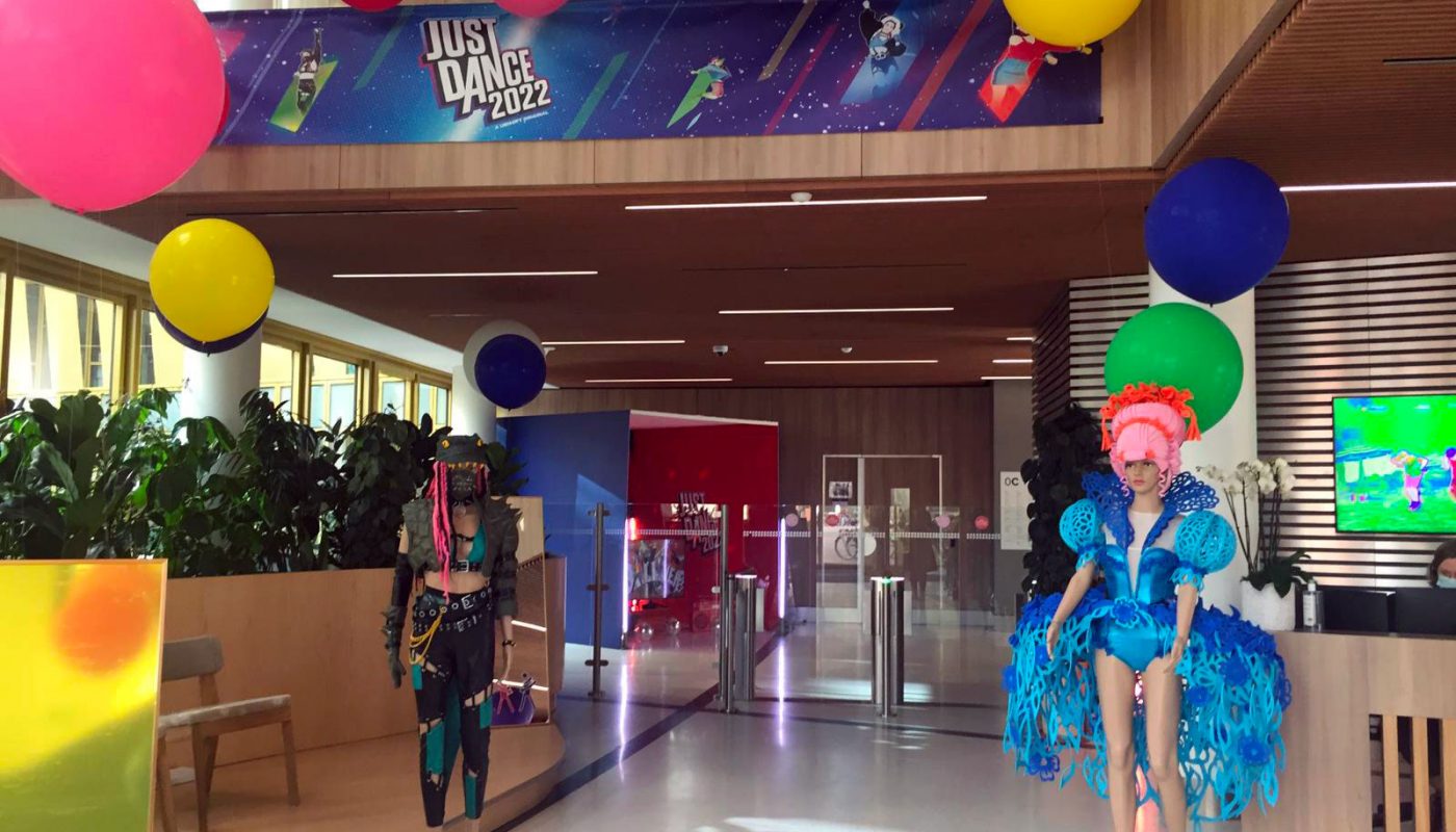 Nuages en ballons colorés, avec des ballons différentes tailles pour le jeu Ubisoft just dance. installation a des hauteurs différentes. Présences de personnages factices dans un hall d'entreprise